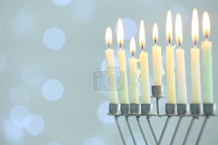 Téléchargez les photos : Hanoukka fête. Menorah avec des bougies allumées contre les lumières floues, espace pour le texte - en image libre de droit