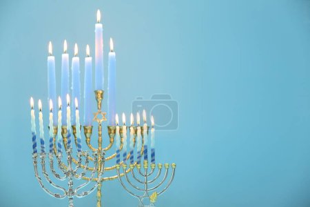 Téléchargez les photos : Hanoukka fête. Menorahs avec des bougies allumées sur fond bleu clair, espace pour le texte - en image libre de droit