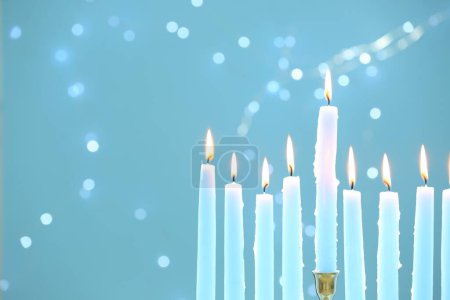 Téléchargez les photos : Hanoukka fête. Brûler des bougies sur fond bleu clair avec des lumières floues, gros plan et espace pour le texte - en image libre de droit