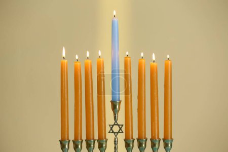 Téléchargez les photos : Hanoukka fête. Menorah avec des bougies allumées sur fond beige, gros plan - en image libre de droit