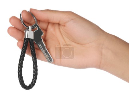 Woman holding key with black leather keychain on white background, closeup