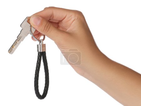 Woman holding key with black leather keychain on white background, closeup
