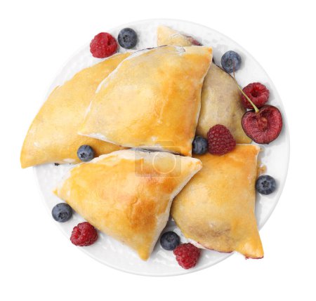 Foto de Deliciosas samosas con cereza y bayas aisladas en blanco, vista superior - Imagen libre de derechos