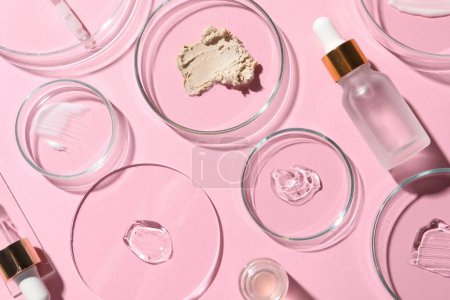 Photo for Bottle of cosmetic serum and petri dishes with samples on pink background, flat lay - Royalty Free Image