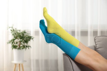 Woman in different stylish socks indoors, closeup