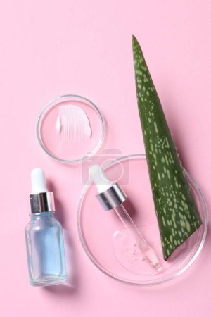 Photo for Bottle of cosmetic serum, aloe vera leaf and petri dishes with samples on pink background, flat lay - Royalty Free Image