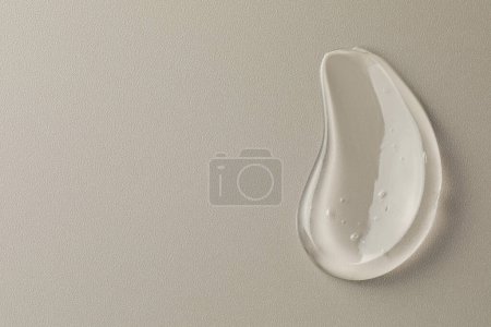 Photo for Smear of clear cosmetic gel on grey background, top view. Space for text - Royalty Free Image