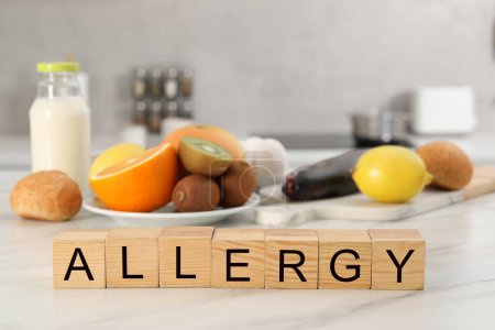Alergia alimentaria. Diferentes productos frescos y cubos de madera sobre mesa de mármol blanco