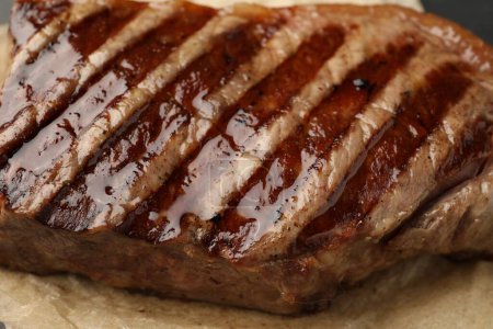 Delicious grilled beef steak on parchment paper, closeup