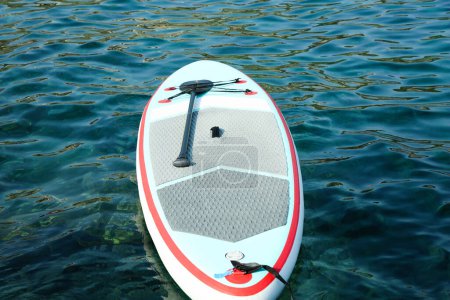 Ein SUP-Board mit Paddel auf Meerwasser
