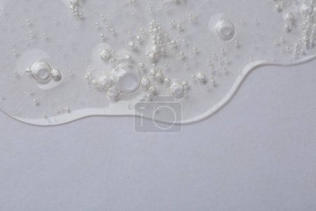 Photo for Clear cosmetic serum on white background, macro view. Space for text - Royalty Free Image