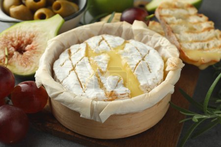 Lecker gebackener Brie-Käse und Produkte auf dem Tisch, Nahaufnahme