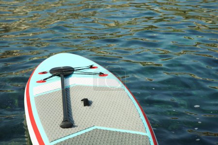 Ein SUP-Board mit Paddel auf Meerwasser