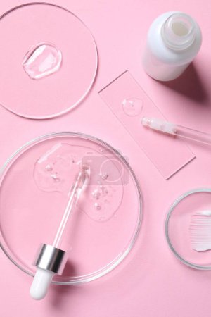 Photo for Bottle of cosmetic serum and petri dishes with samples on pink background, flat lay - Royalty Free Image
