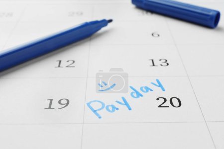 Photo for Blue felt pen on calendar page with marked payday date, closeup - Royalty Free Image