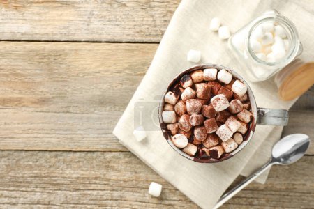 Photo for Delicious hot chocolate with marshmallows and cocoa powder in cup on wooden table, flat lay. Space for text - Royalty Free Image