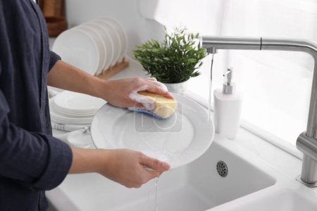 Foto de Placa de lavado de mujer en el fregadero en la cocina, primer plano - Imagen libre de derechos