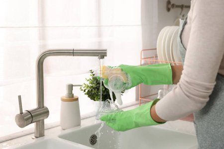 Foto de Mujer lavando vidrio en el fregadero en la cocina, primer plano - Imagen libre de derechos