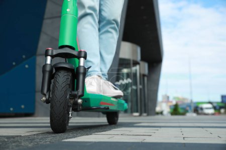 Photo for Man riding modern electric kick scooter on city street, closeup. Space for text - Royalty Free Image