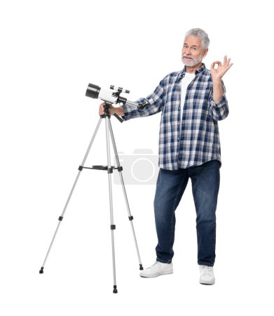 Senior Astronom mit Teleskop zeigt Okay-Geste auf weißem Hintergrund