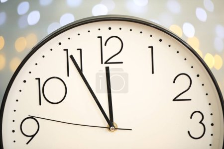 Photo for Clock showing five minutes until midnight on blurred background, closeup. New Year countdown - Royalty Free Image