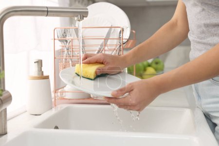 Foto de Placa de lavado de mujer en el fregadero en la cocina, primer plano - Imagen libre de derechos