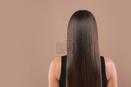 Photo for Hair styling. Woman with straight long hair on pale brown background, back view. Space for text - Royalty Free Image