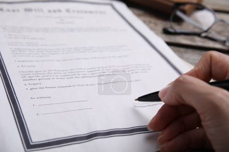 Photo for Woman signing last will and testament at table, closeup - Royalty Free Image