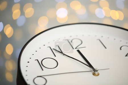 Photo for Clock showing five minutes until midnight on blurred background, closeup. New Year countdown - Royalty Free Image