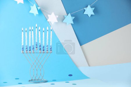 Téléchargez les photos : Hanoukka fête. Menorah avec des bougies brûlantes sur fond de couleur, espace pour le texte - en image libre de droit