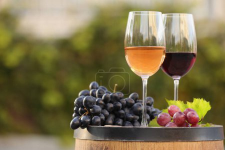 Téléchargez les photos : Délicieux vins et raisins mûrs sur tonneau en bois à l'extérieur, espace pour le texte - en image libre de droit