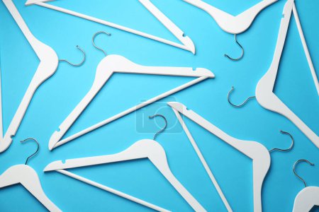 Photo for White hangers on light blue background, flat lay - Royalty Free Image