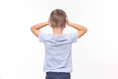 Dyslexia problem. Boy covering head with hands on white background, back view