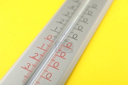 Thermomètre météo moderne sur fond jaune, gros plan