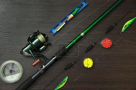 Photo for Fishing tackle on dark wooden background, flat lay - Royalty Free Image