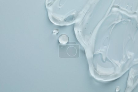 Photo for Clear cosmetic gel on light blue background, top view. Space for text - Royalty Free Image