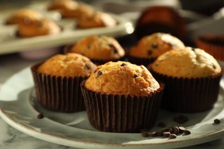 Photo for Delicious sweet muffins with chocolate chips on white marble table, closeup - Royalty Free Image