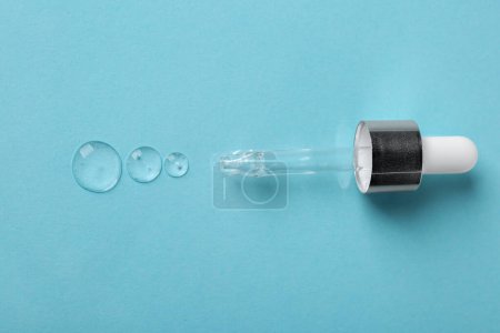 Photo for Clear cosmetic serum and pipette on light blue background, top view - Royalty Free Image