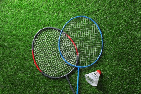Photo for Two badminton rackets and shuttlecock on green grass, top view - Royalty Free Image