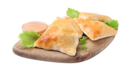 Foto de Tablero de madera con deliciosas samosas, lechuga y salsa aisladas en blanco - Imagen libre de derechos