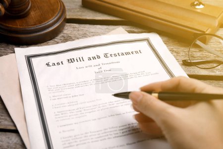 Woman reading Last Will and Testament at wooden table, closeup