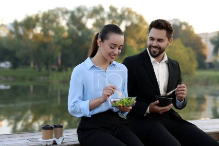 Téléchargez les photos : Des gens d'affaires souriants passent du temps ensemble pendant le déjeuner à l'extérieur - en image libre de droit