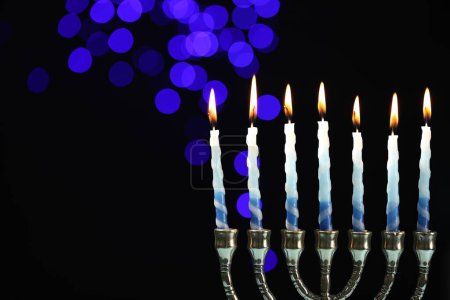 Téléchargez les photos : Hanoukka fête. Menorah avec des bougies brûlantes sur fond sombre avec des lumières floues, espace pour le texte - en image libre de droit