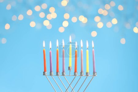 Téléchargez les photos : Hanoukka fête. Menorah avec des bougies allumées sur fond bleu clair avec des lumières floues - en image libre de droit