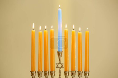 Téléchargez les photos : Hanoukka fête. Menorah avec des bougies allumées sur fond beige, gros plan - en image libre de droit