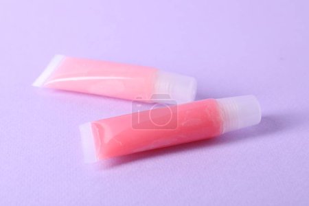 Photo for Different lip balms on lilac background, closeup - Royalty Free Image