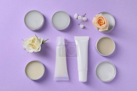 Photo for Flat lay composition with lip balms and flowers on lilac background - Royalty Free Image