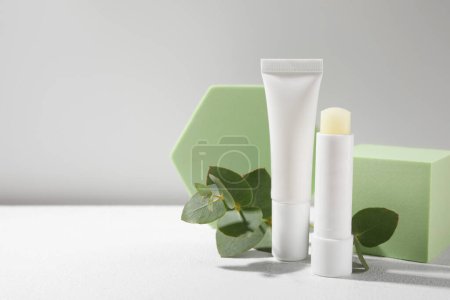 Photo for Stylish presentation of different lip balms on white table, space for text - Royalty Free Image