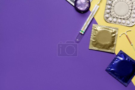 Contraceptive pills, condoms, intrauterine device and thermometer on color background, flat lay with space for text. Different birth control methods