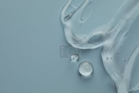 Photo for Clear cosmetic gel on light blue background, top view. Space for text - Royalty Free Image